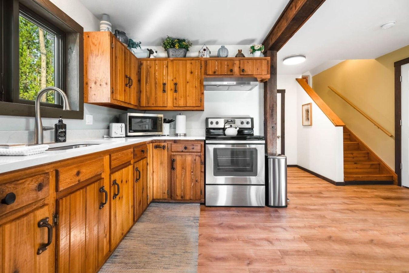 Eine moderne Küche mit Holzausstattung, Edelstahlgeräten und Blick ins Freie.