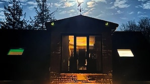 A building with a prominent entrance, a visible clock, and a weather vane on the roof. - Riverside Country Retreat, Holiday Rental HotTub  Pizza Oven (Kirtlebridge)
