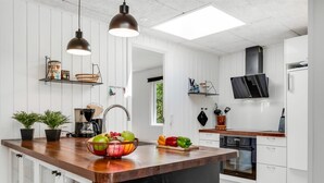 A modern kitchen with a central island, pendant lighting, and a view of the outdoors. - "Eli" - 1.5km to the fjord by Interhome (Blåvand)