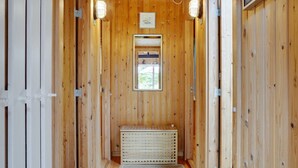 A wooden hallway with a radiator, a framed picture, and a window at the end. - "Herlek" - 200m from the sea by Interhome (Knebel)