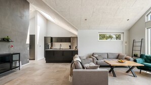 Un espace de vie moderne comprenant une cuisine, un coin repas et un espace détente.