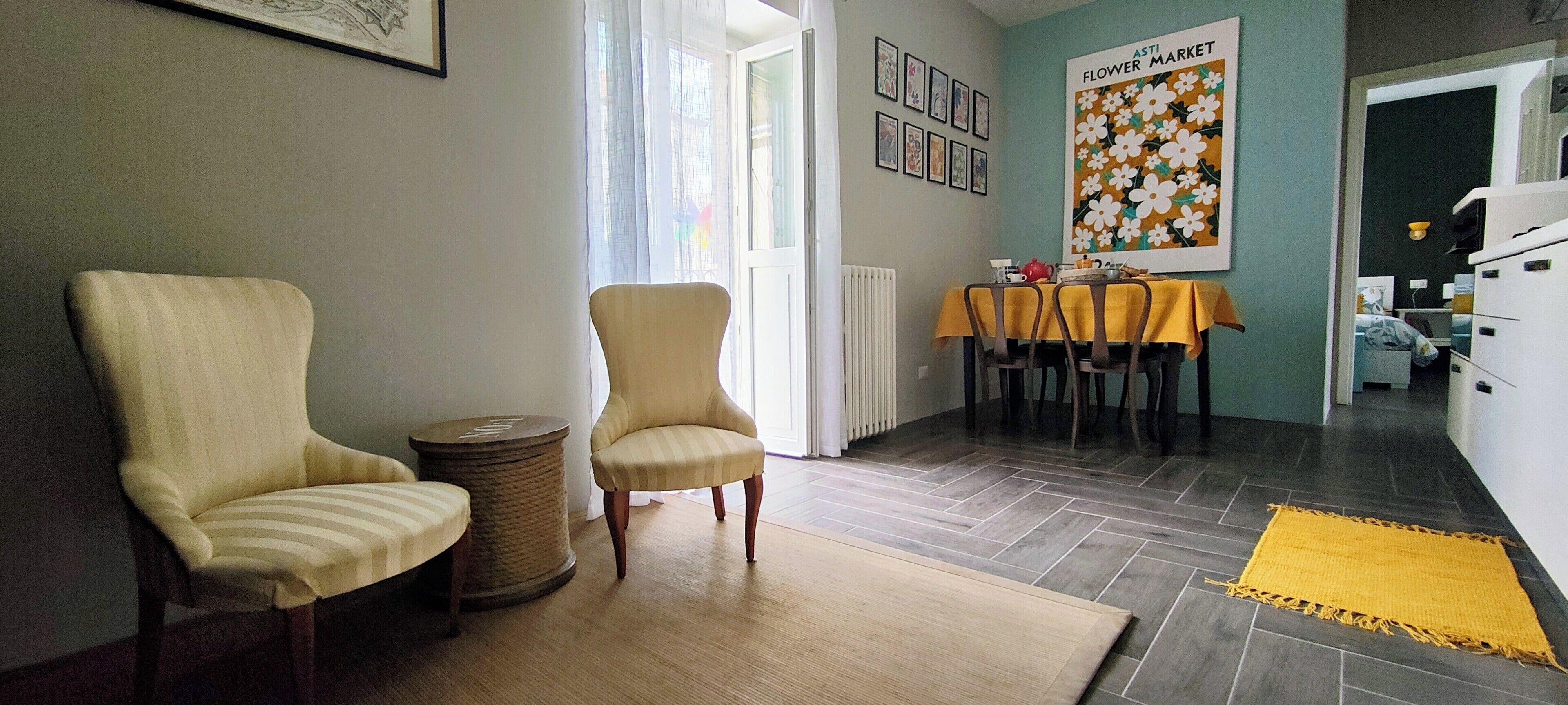 Una sala de estar con dos sillones, una mesa de centro y un comedor con una mesa y sillas.