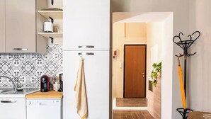 Une cuisine moderne équipée d’un lave-vaisselle, d’une machine à café et d’un porte-serviettes mural.
