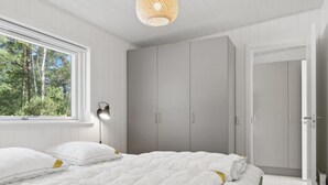 Une chambre à coucher avec un lit, une armoire et une fenêtre.