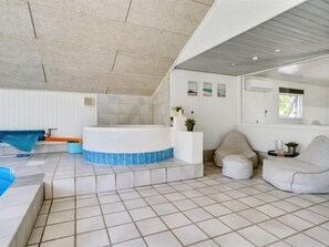 Relax in a spacious room with a large hot tub and cozy seating area.