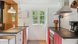 Een moderne keuken met witte kasten, een groot raam en een koffieapparaat.