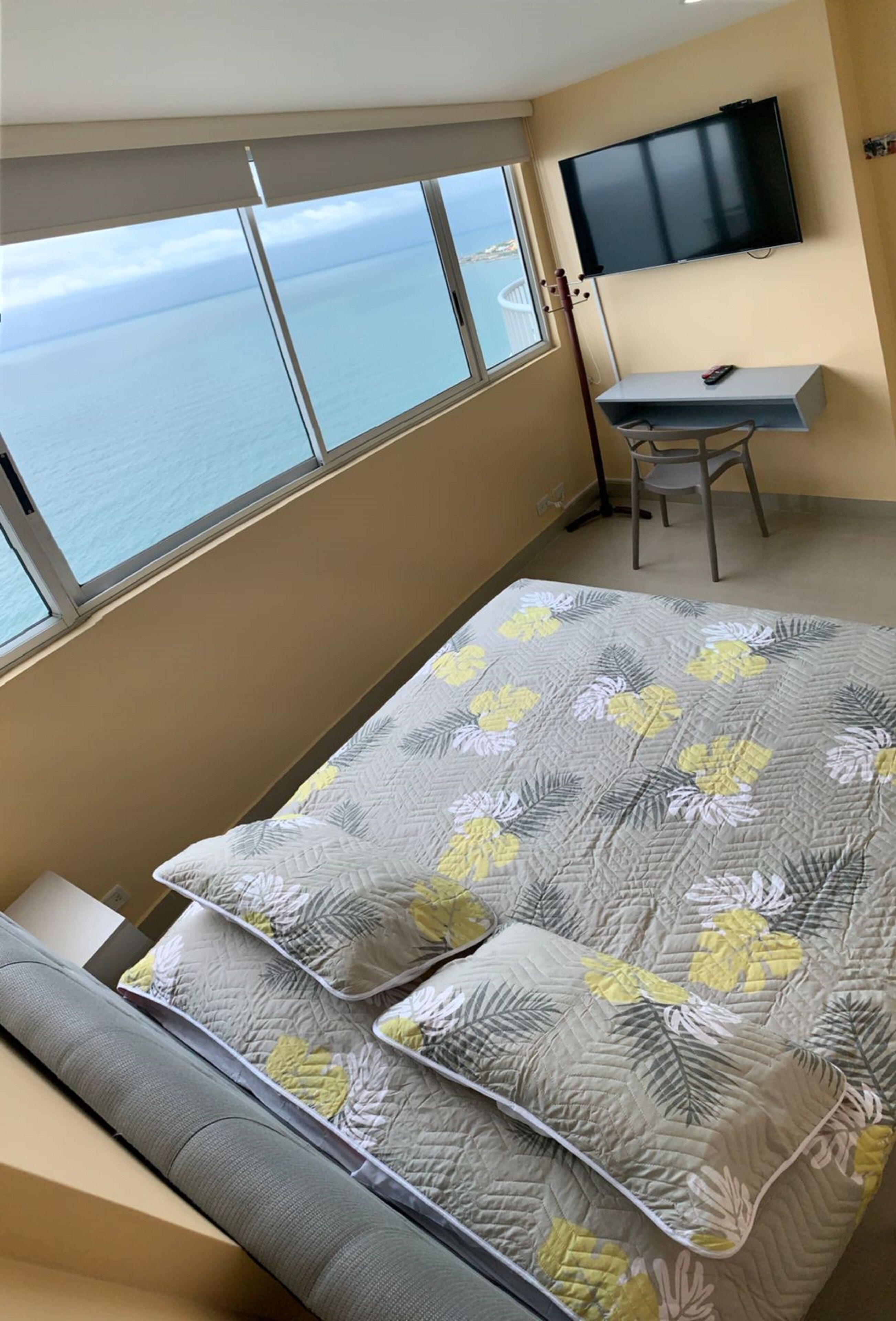 Ein Schlafzimmer mit Bett, Schreibtisch und Fernseher.