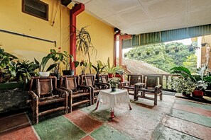 Una habitación con muebles de madera, una mesita pequeña y plantas en macetas.