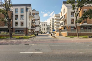 A modern apartment building with multiple floors, balconies, and a central courtyard.