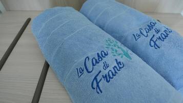 Two rolled-up towels with embroidered text.