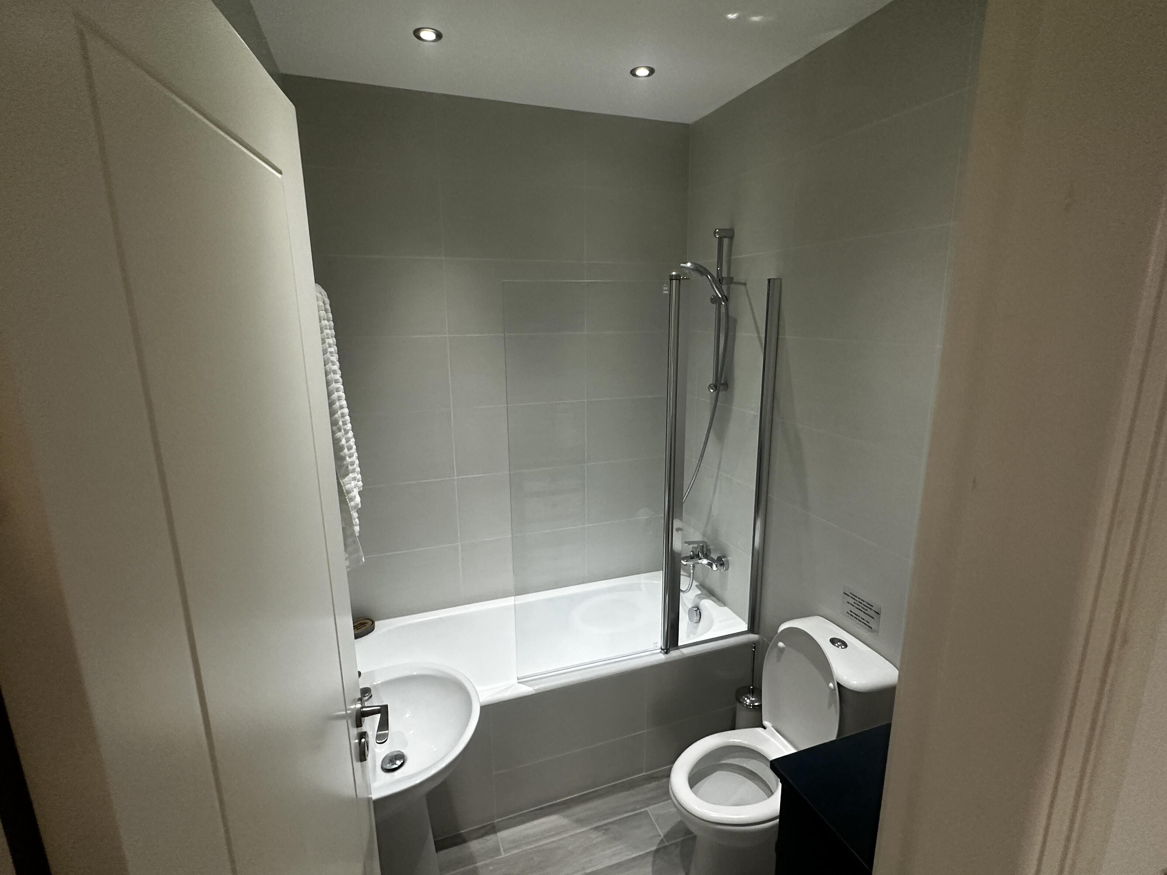 A modern bathroom with a bathtub, toilet, and sink.