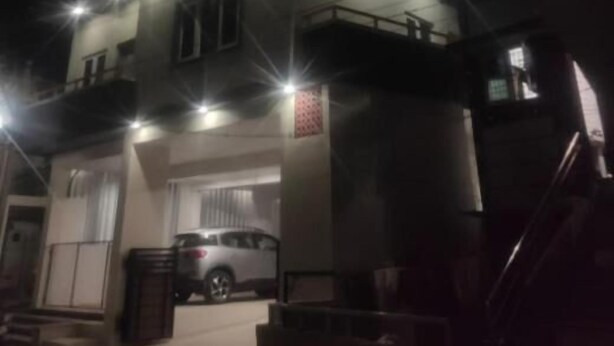 A multi-story building with a parking garage at the ground level. - Moshis Nest (Madurai)