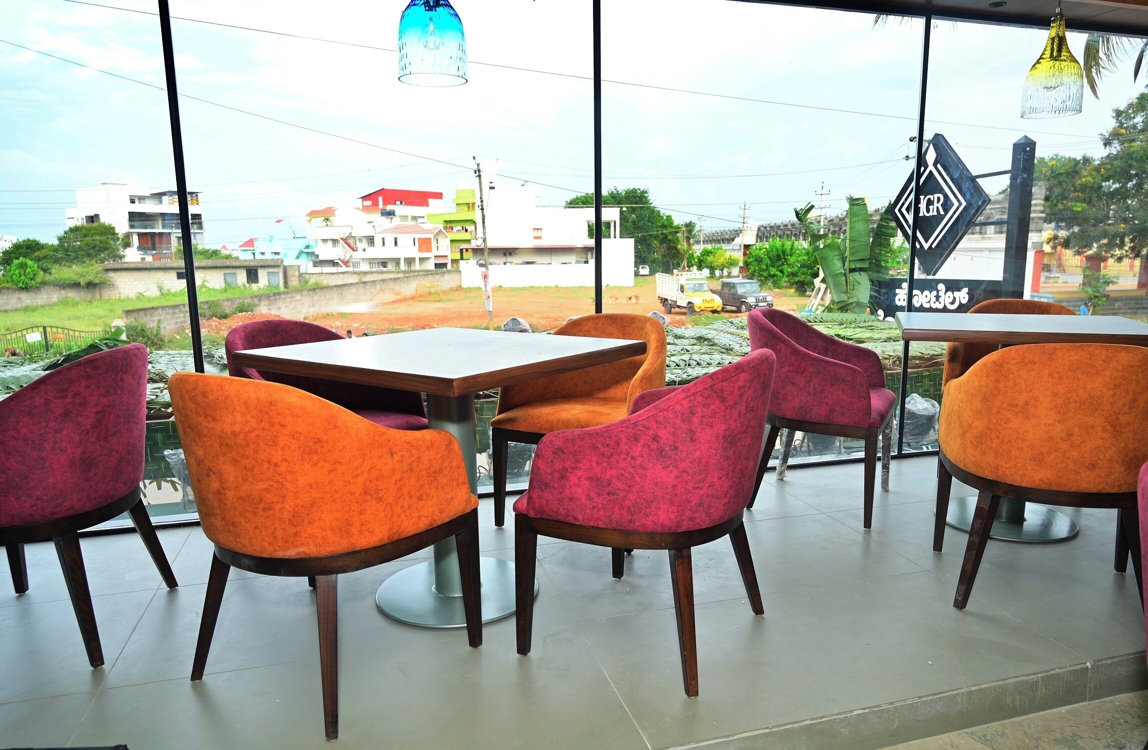 Un ristorante con vista sulla città, caratterizzato da sedie e tavoli colorati.