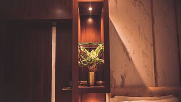 Un meuble en bois doté d’une porte en verre, à l’intérieur duquel se trouve une plante en pot.