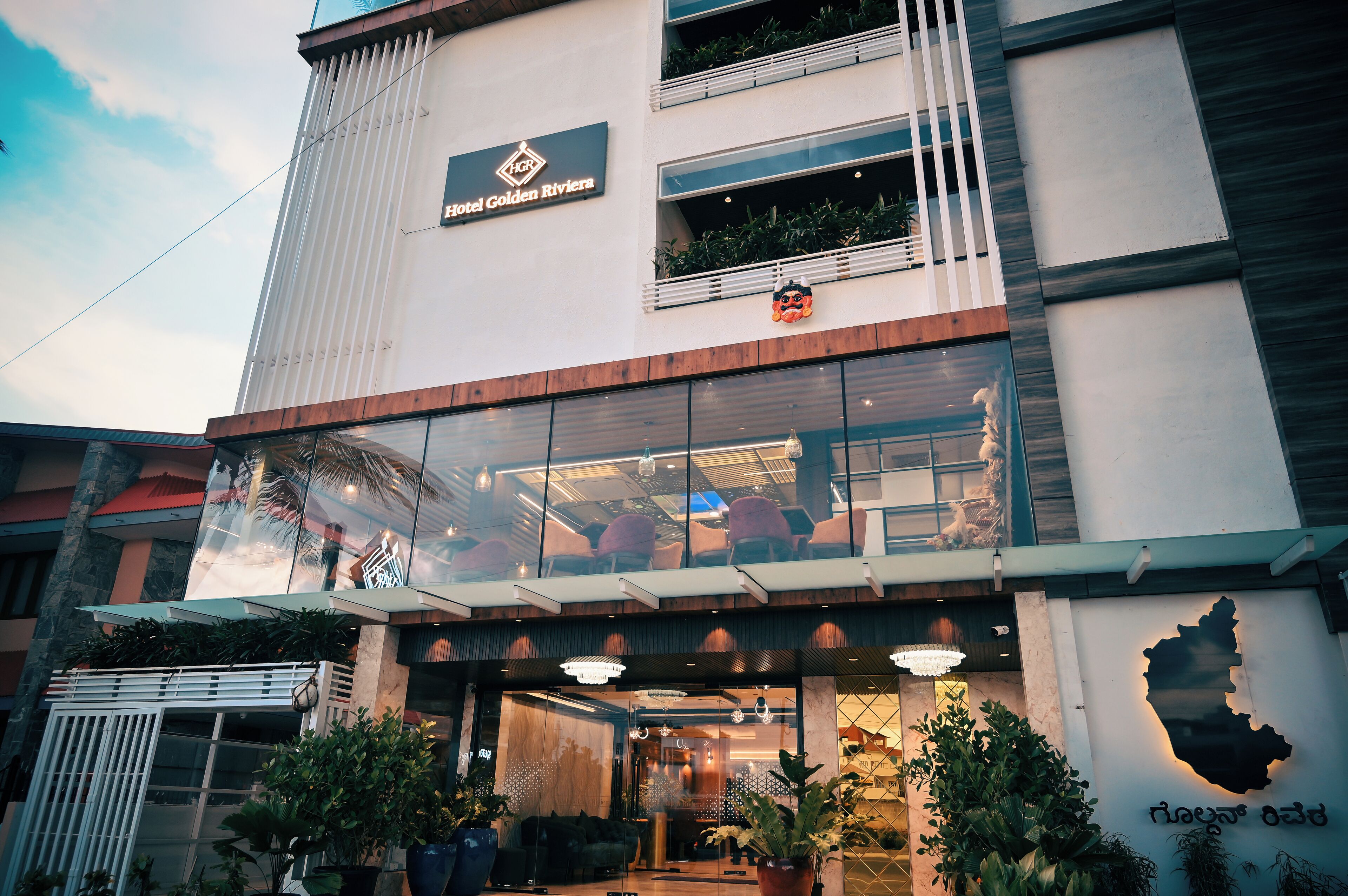 The exterior of Hotel Golden Riviera with a modern design, large windows, and a prominent entrance.