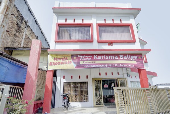A building with a sign that reads "Karisma Balige" and "Harga Ekonomis".