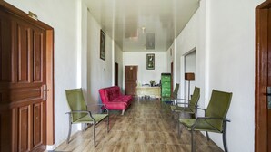 Ein Korridor mit Holzboden, grünen Stühlen, einem roten Sofa und einem grünen Aktenschrank.