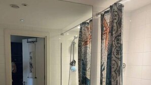Un baño con un lavamanos blanco, un inodoro y una ducha.