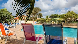A poolside area with lounge chairs and a clear view of the pool. - 12B Flamingo by Bonaire Paradise (Kralendijk)