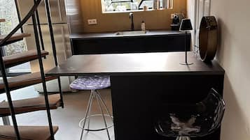 Een moderne keuken met een centraal eiland, roestvrijstalen apparatuur en een raam met uitzicht.
