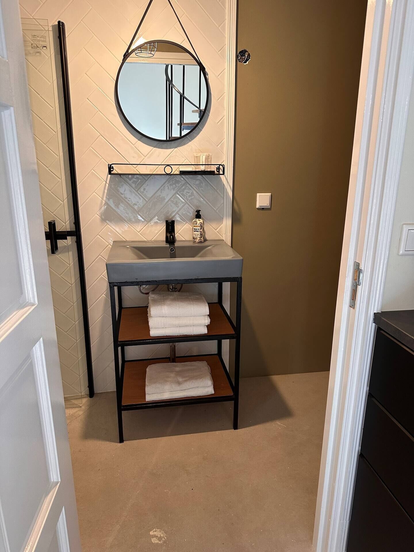 A bathroom with a sink, mirror, and towel rack.