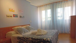 A bedroom with a bed, a nightstand, a wardrobe, and wall decorations including license plates. - Apartamento Vigo Playa-ciudad II (Vigo)