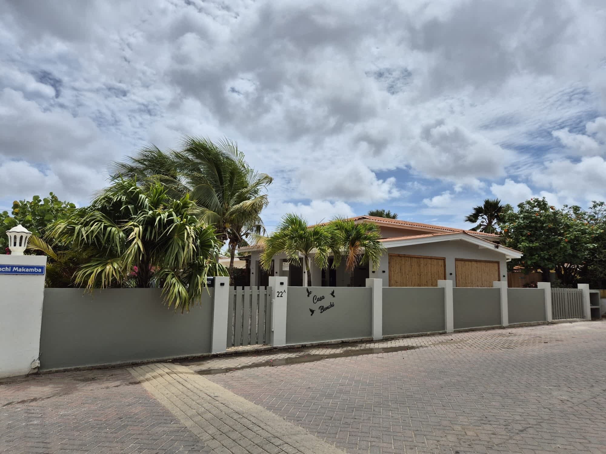 A residential property with a gated entrance, a paved driveway, and a clear sky.
