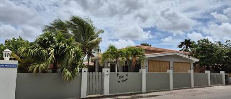 A residential property with a gated entrance, a paved driveway, and a clear sky.