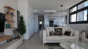 Een moderne woonkamer met een bank, een salontafel en een televisie.