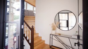 A staircase with wooden steps and a glass door leading to an outdoor area.
