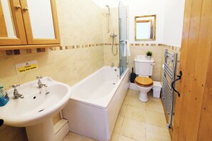 A bathroom with a sink, bathtub, toilet, and shower.