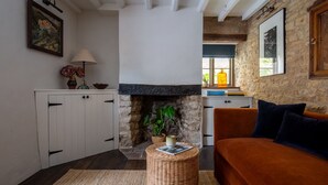 Ein gemütliches Wohnzimmer mit Kamin, Sofa, Couchtisch und Bücherregal.