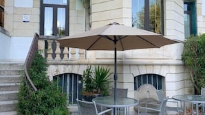 A building with a sign reading "BEAUSOLEIL" and outdoor seating with a large umbrella. - Hôtel Beausoleil (Montélimar)