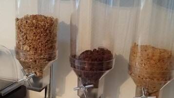 Tres dispensadores con diferentes alimentos, un cuenco de bocadillos empaquetados y un tarro de azúcar.