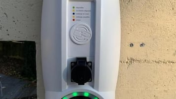 A public EV charging station with a digital display and a charging plug.