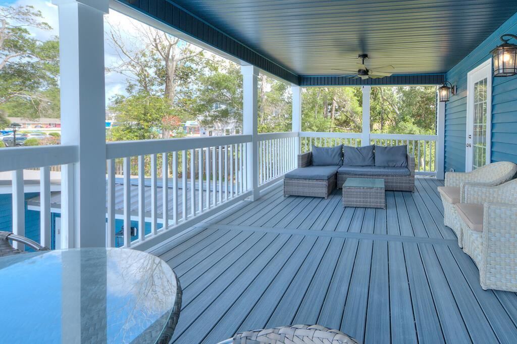 A covered porch with a seating area, a pool, and a view of the surrounding area.