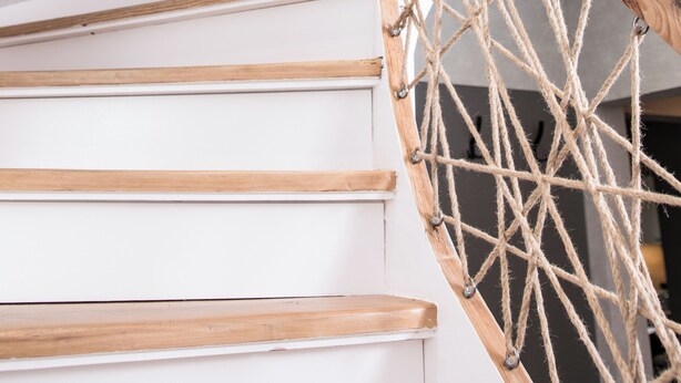 A wooden staircase with a rope barrier.