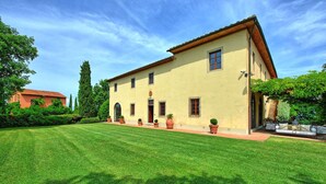 A two-story building with a tiled roof, a well-maintained lawn, and potted plants along the front. - Villa Marliana - Luxury Villa with private pool (Cerreto Guidi)