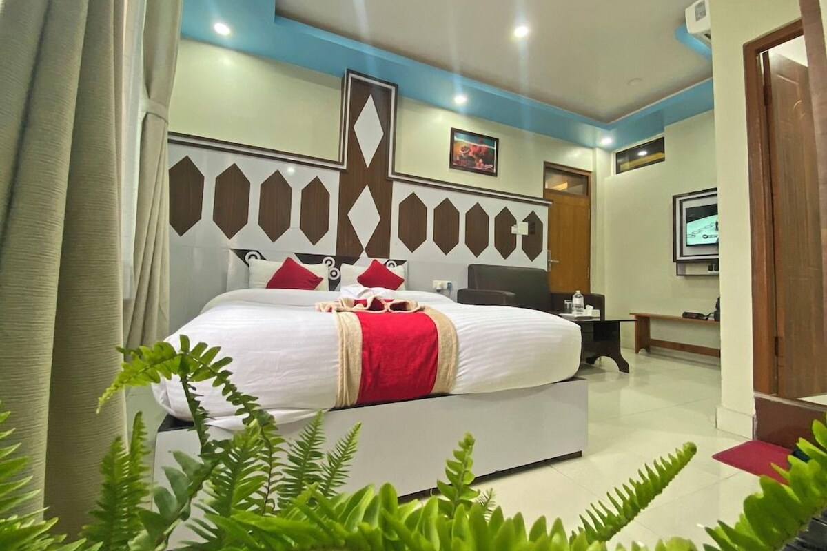 A hotel room with a bed, a desk, and a television.