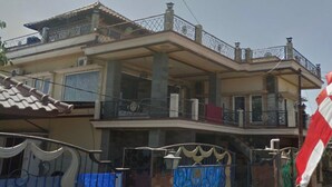 A two-story house with a balcony, a gated entrance, and a flag. - OYO 3887 Potreh Mastekah 2 (Banten)