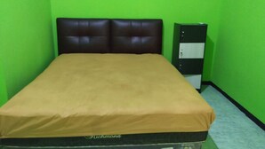 A room with a bed, green walls, and a black and white filing cabinet. - OYO 3887 Potreh Mastekah 2 (Banten)