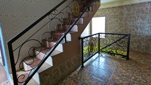 A staircase with ornate metal railings, patterned walls, and tiled flooring. - OYO 3887 Potreh Mastekah 2 (Banten)