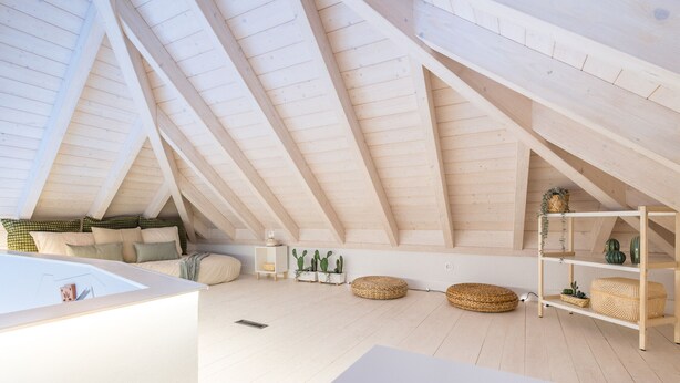 A spacious attic room with a sloped ceiling, wooden beams, a white sofa, a small table, and wicker baskets. - Suits Boutique Ala - Studio mezanino by HD (Faro)