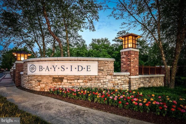 A stone wall with a sign reading 'BAYSIDE' and a brick tower with lights. - Bayside * 4BR Luxury Twinhouse (Selbyville)