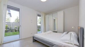 A modern bedroom with a bed, bedside table, and a large mirror.