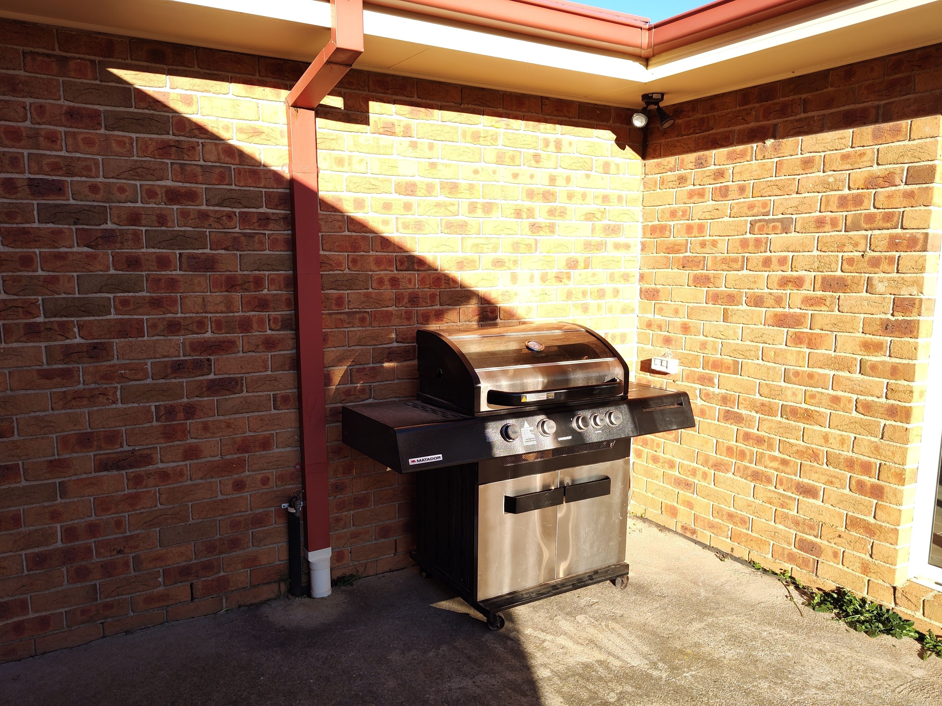 A brick wall with a metal grill attached to it.