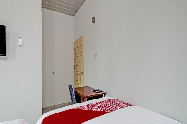 A room with a bed, a desk, a chair, and a wardrobe.