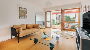 A modern living room with a sofa, coffee table, and TV. - Sixties 64 :  2 bedrooms apartment with a balcony and parking in Biarritz (Biarritz)