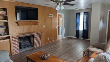 Smart-tv, eldstad, böcker och kontor