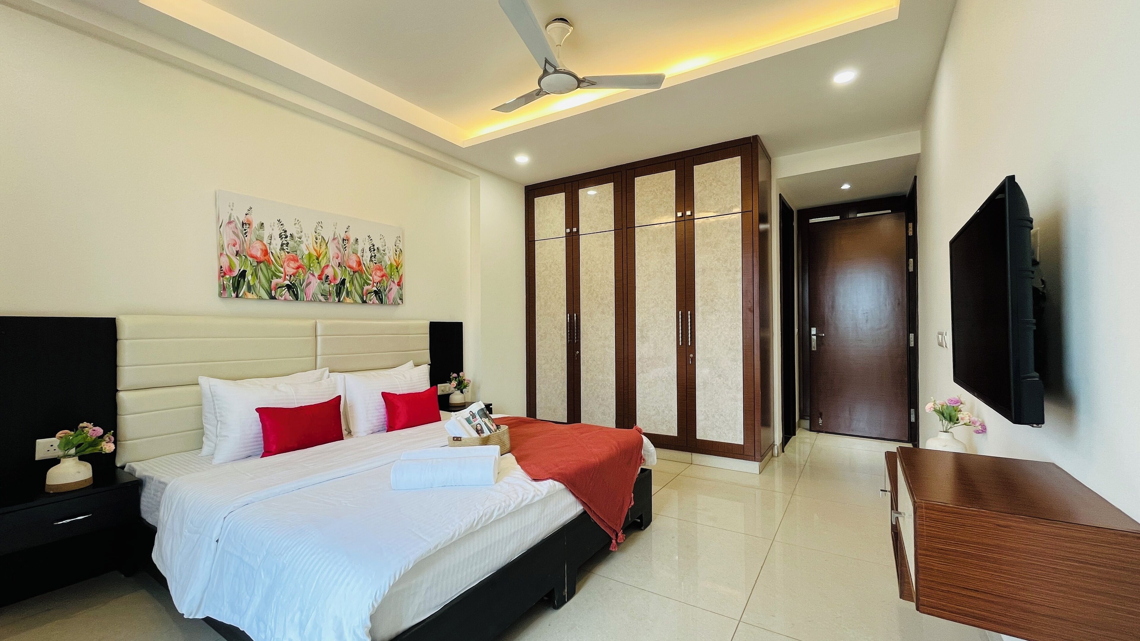 Une chambre d’hôtel équipée d’un lit, d’une armoire, d’une télévision et d’un ventilateur de plafond.